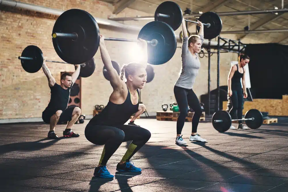 personas levantando pesas en el gimnasio haciendo cross training